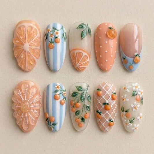 Macro view of 3D textured orange slice nail art and delicate hand-painted leaves on salon-grade gel tips, perfect for a fresh summer manicure.