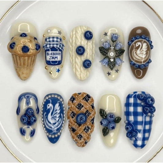 Artistic cottagecore-themed reusable nails with 3D blueberry and woven crust details.