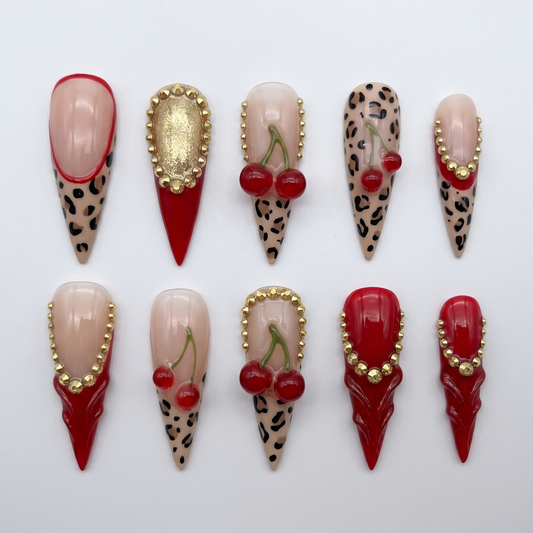 Y2K cherry and leopard French tip stiletto nails with gold rhinestone detailing