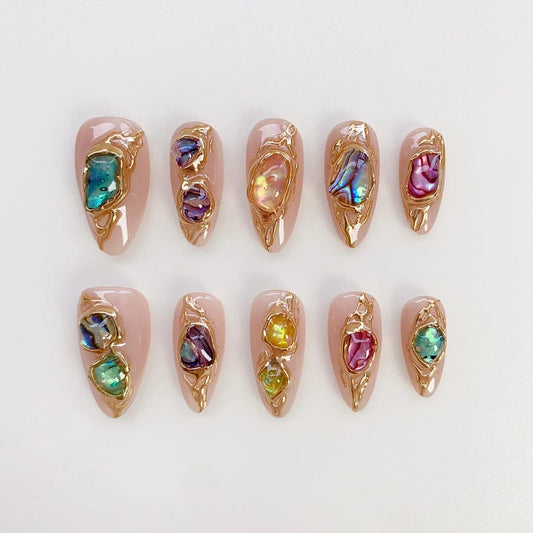 Elegant stiletto-shaped reusable nails featuring artistic gold-framed crystal designs