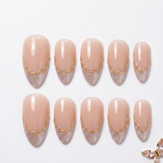 Close-up of manicured hands holding a perfume bottle, showcasing luxury press-on nails with a sophisticated French tip and delicate gold design.