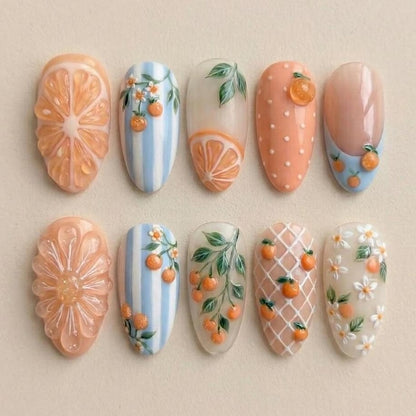 Macro view of 3D textured orange slice nail art and delicate hand-painted leaves on salon-grade gel tips, perfect for a fresh summer manicure.