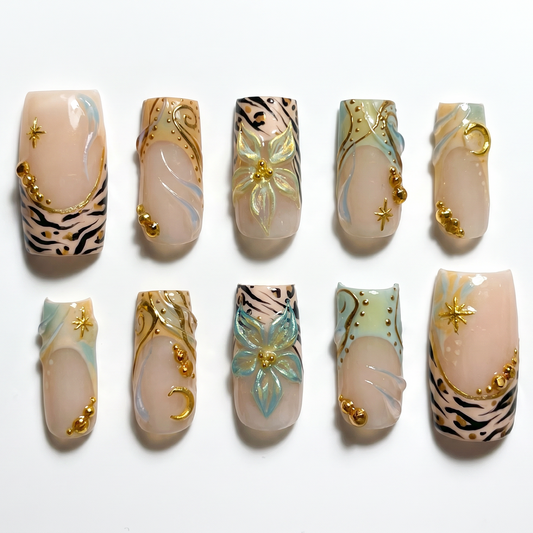 Boho celestial press-on nail set featuring gold swirl art, animal print and teal watercolor on warm nude