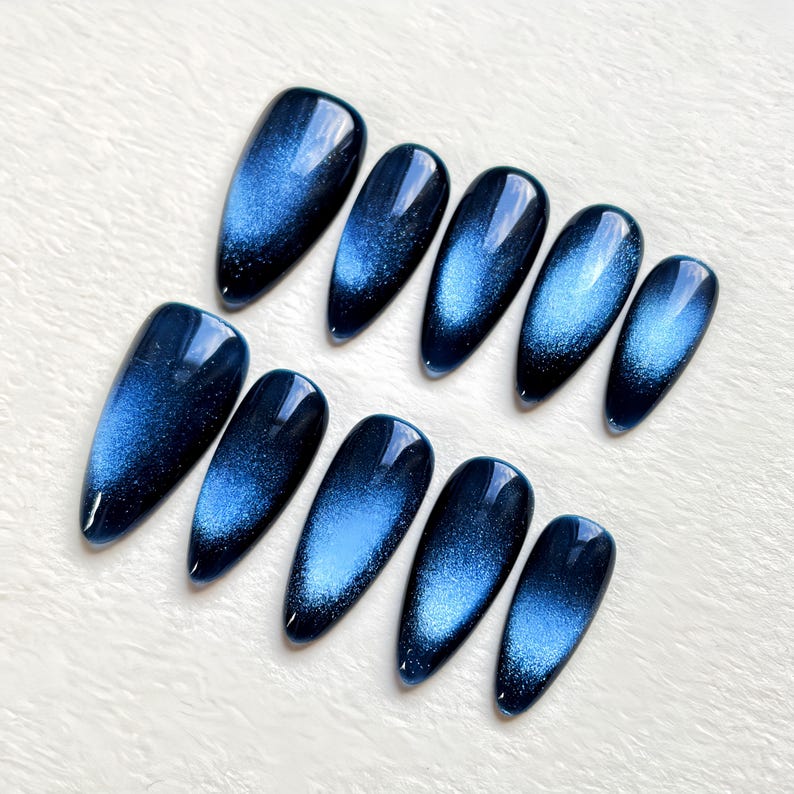 Elegant almond-shaped press-on nails in a deep midnight blue shade, showcasing high-quality magnetic cat eye nail art by JRNAIL.
