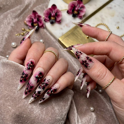 JRNAIL high-fashion stiletto fake nails showcasing a glossy salon gel finish with dramatic orchid flower art and romantic gothic details, perfect for a custom DIY home manicure.