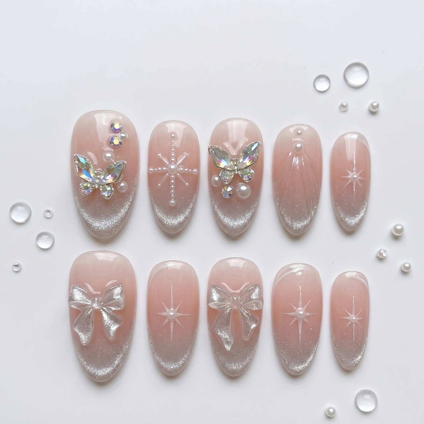 Romantic press-on nails with a dreamy nude base, sparkling starburst art, and luminous 3D butterfly charms for a feminine, coquette-inspired look.