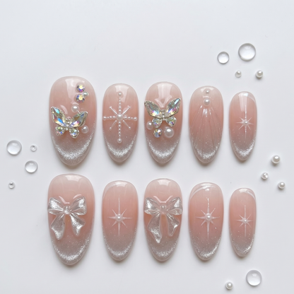 Romantic press-on nails with a dreamy nude base, sparkling starburst art, and luminous 3D butterfly charms for a feminine, coquette-inspired look.
