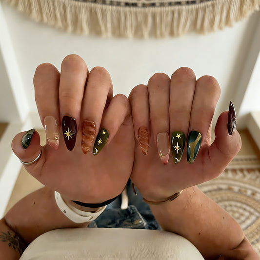 Luxury bohemian fake nails with gold foil, 3D amber swirls, and celestial motifs on glossy almond-shaped press ons