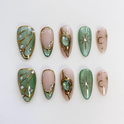 Luxury art deco press on nails with gold filigree, nude pink base, and emerald green gem details