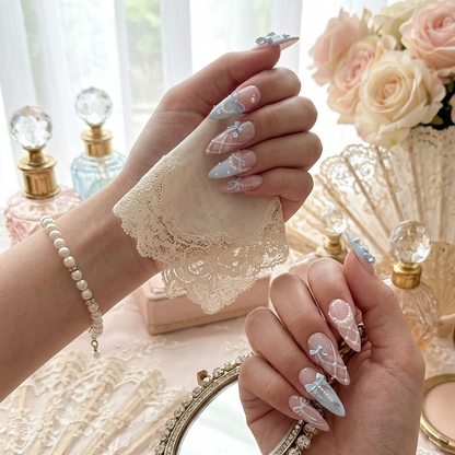 Dreamy pastel blue and pink coquette-style press-on nails featuring 3D bows, pearl accents, and sparkling glitter details by JRNAIL.