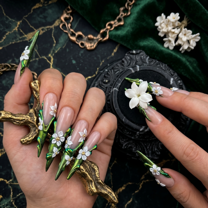 Luxurious hand-sculpted 3D floral press-on nails in deep emerald green chrome with delicate white blossoms and gold accents by JRNAIL.