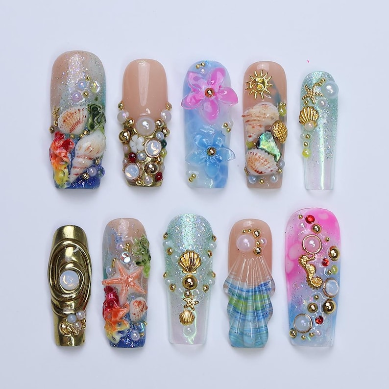 3D mermaidcore fake nails with deep sea details, seashells, seahorses, and iridescent blue-pink finish