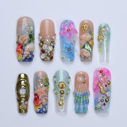 3D mermaidcore fake nails with deep sea details, seashells, seahorses, and iridescent blue-pink finish