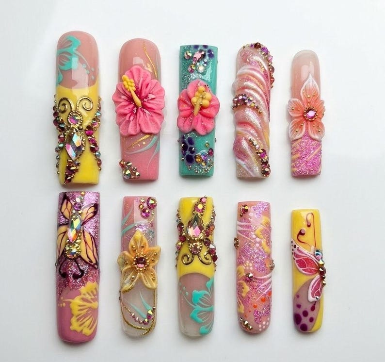 Artistic vacation-ready press-on nails in neon tropical colors with intricate 3D floral art, perfect for a bold island-inspired manicure.