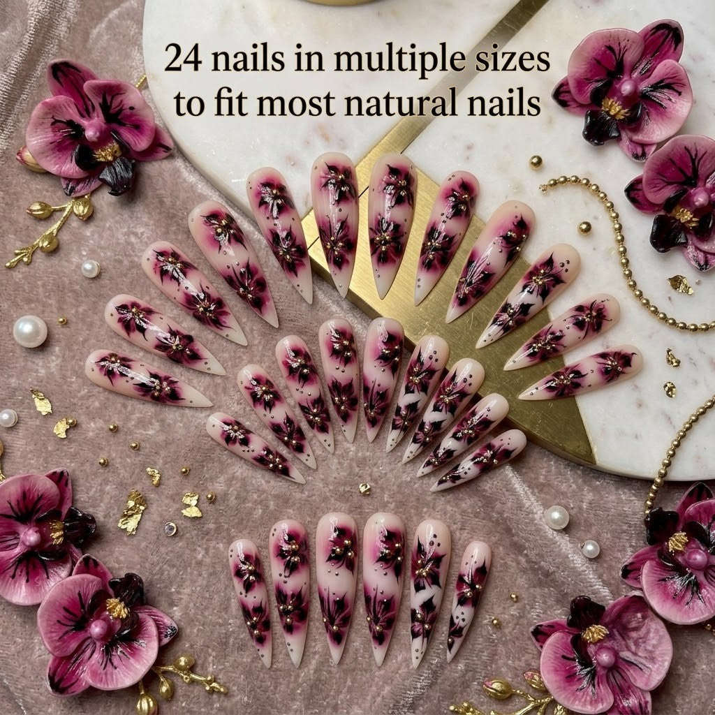 A full 24-piece luxury press-on nail set featuring sharp stiletto tips with hand-painted burgundy orchid flower designs and gold caviar beads, arranged in an elegant fan layout on a velvet and marble background with text reading '24 nails in multiple sizes to fit most natural nails.