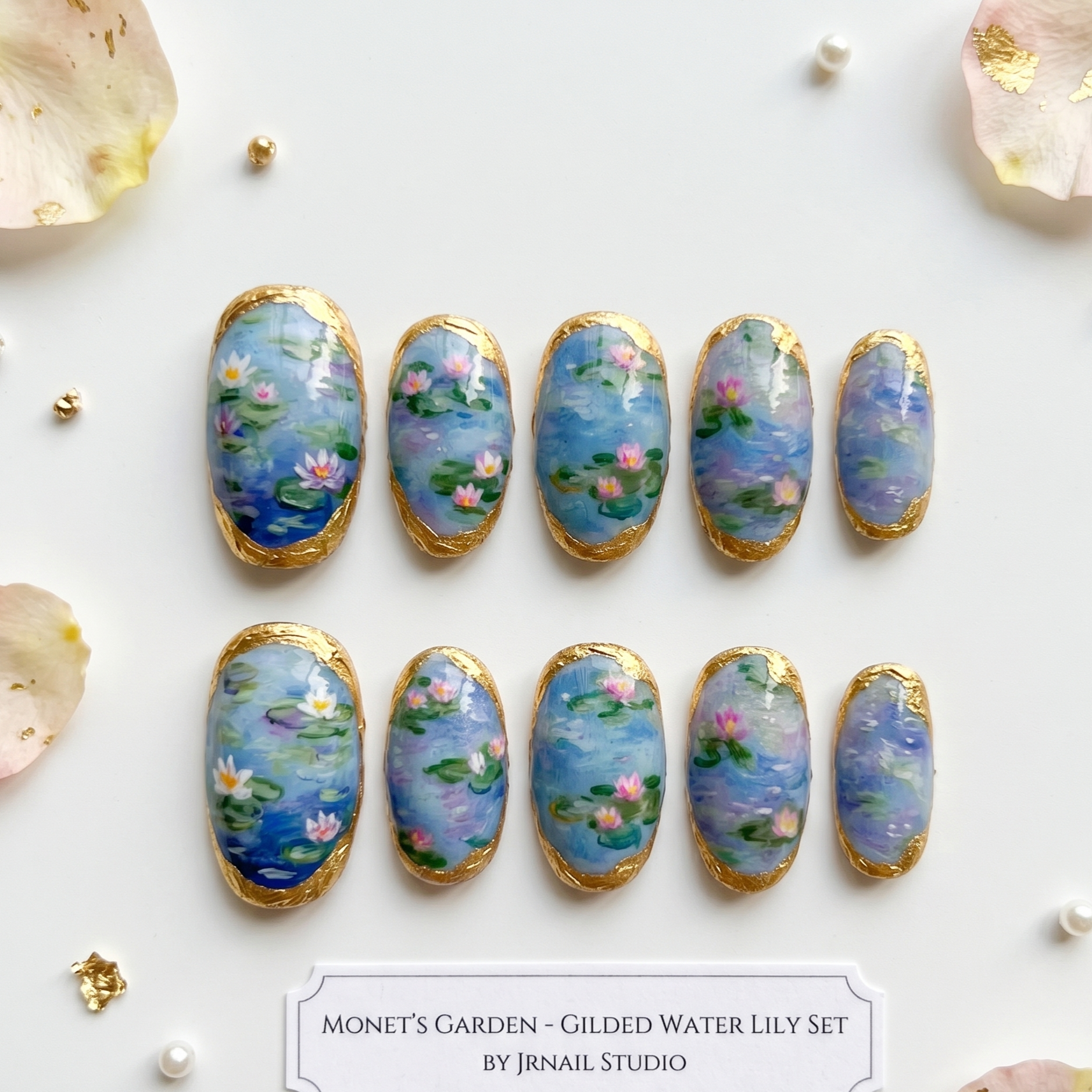 Artistic, hand-painted gel press-on nails inspired by Monet’s water garden, showcasing soft blues, purples, and premium gold-leaf detailing.