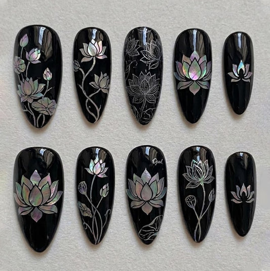 Luxury almond-shaped press-on nails with mother-of-pearl lotus art on a glossy black base, perfect for a sophisticated, artistic look.
