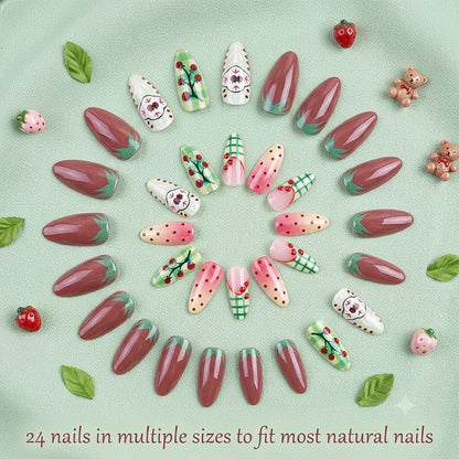 A top-down product display showing 24 pieces of press-on nails in various sizes arranged beautifully in a circular pattern on a light green fabric background with mini resin bears and strawberries.