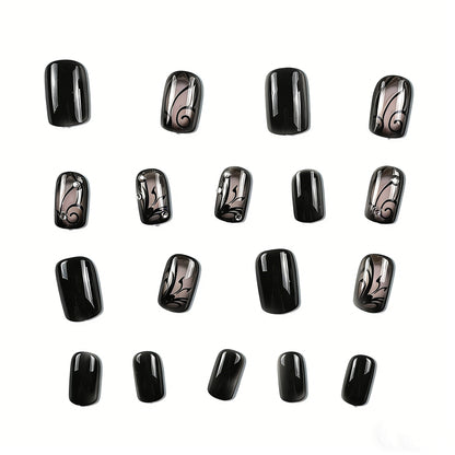 Close-up of hand wearing JRNAILS black and nude press on nails with intricate butterfly art and crystal embellishments