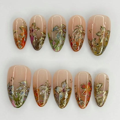 Sophisticated floral gel manicure set with intricate gold-embossed details and earthy tones