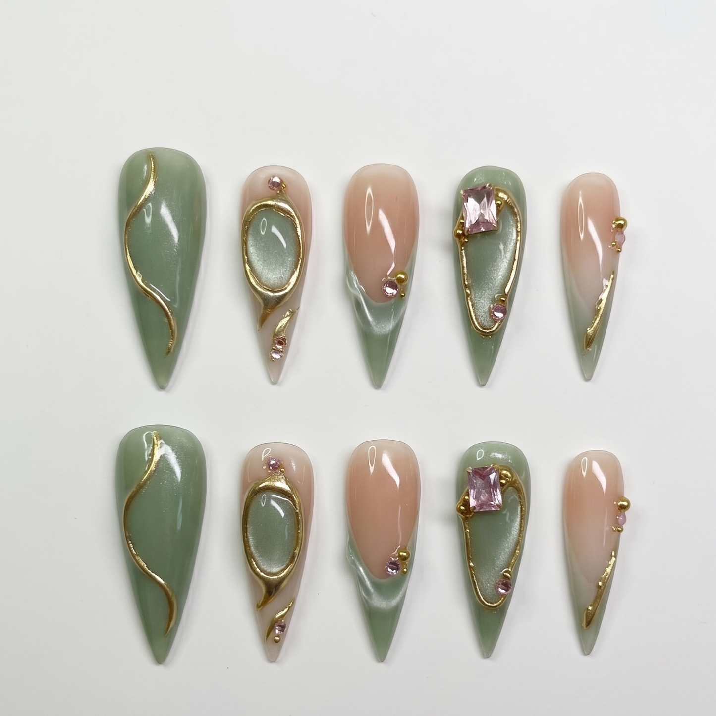 Premium artisan stiletto-shaped press-on nails adorned with delicate gold lines and shimmering crystals for a high-fashion look.