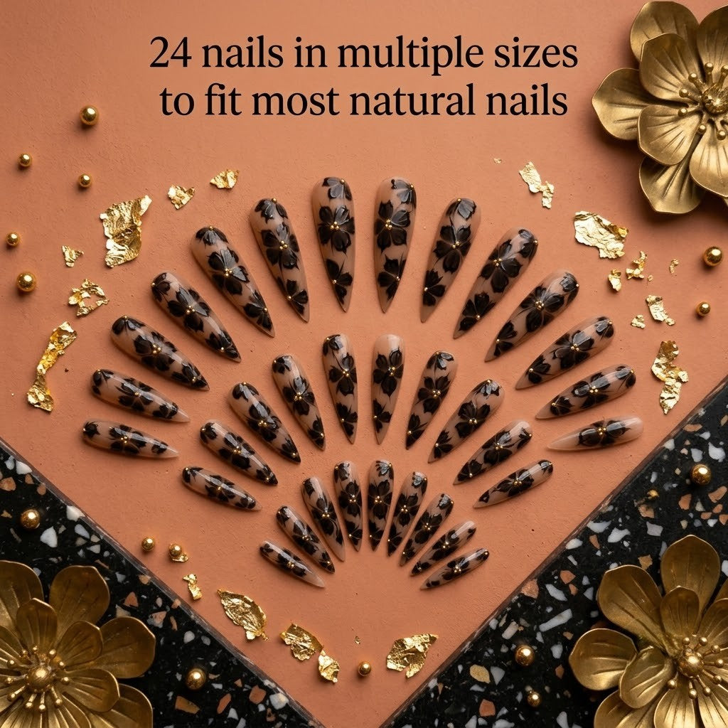 A premium 24-piece luxury press-on nail set featuring sharp stiletto tips with translucent black floral designs, gold caviar beads, and gold foil flakes, beautifully arranged in a semi-circular fan pattern on a warm terracotta background with text reading '24 nails in multiple sizes to fit most natural nails.