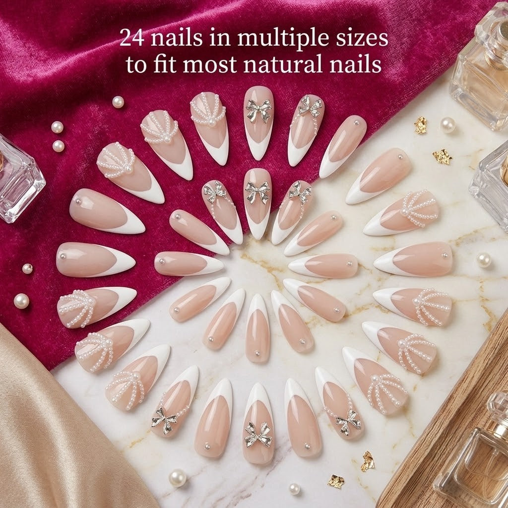 A premium 24-piece luxury press-on nail set featuring elongated stiletto tips with crisp white French manicures, 3D silver bow charms, and micro-pearl drapes, arranged in a double radial circle on white marble and deep magenta velvet with text reading '24 nails in multiple sizes to fit most natural nails.