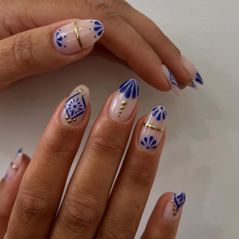 Minimalist nude manicure with blue abstract flowers and gold lines