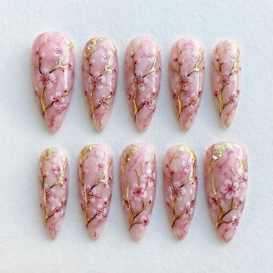 Elegant pink marble nail art set featuring delicate sakura flower patterns for a romantic look.