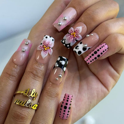 3D lily flower fake nails with black and white polka dots, silver metal studs, and glossy coffin shape