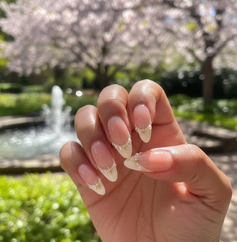 Professional-grade, reusable almond press-on nails with intricate pearl and celestial jewelry design by JRNAIL.