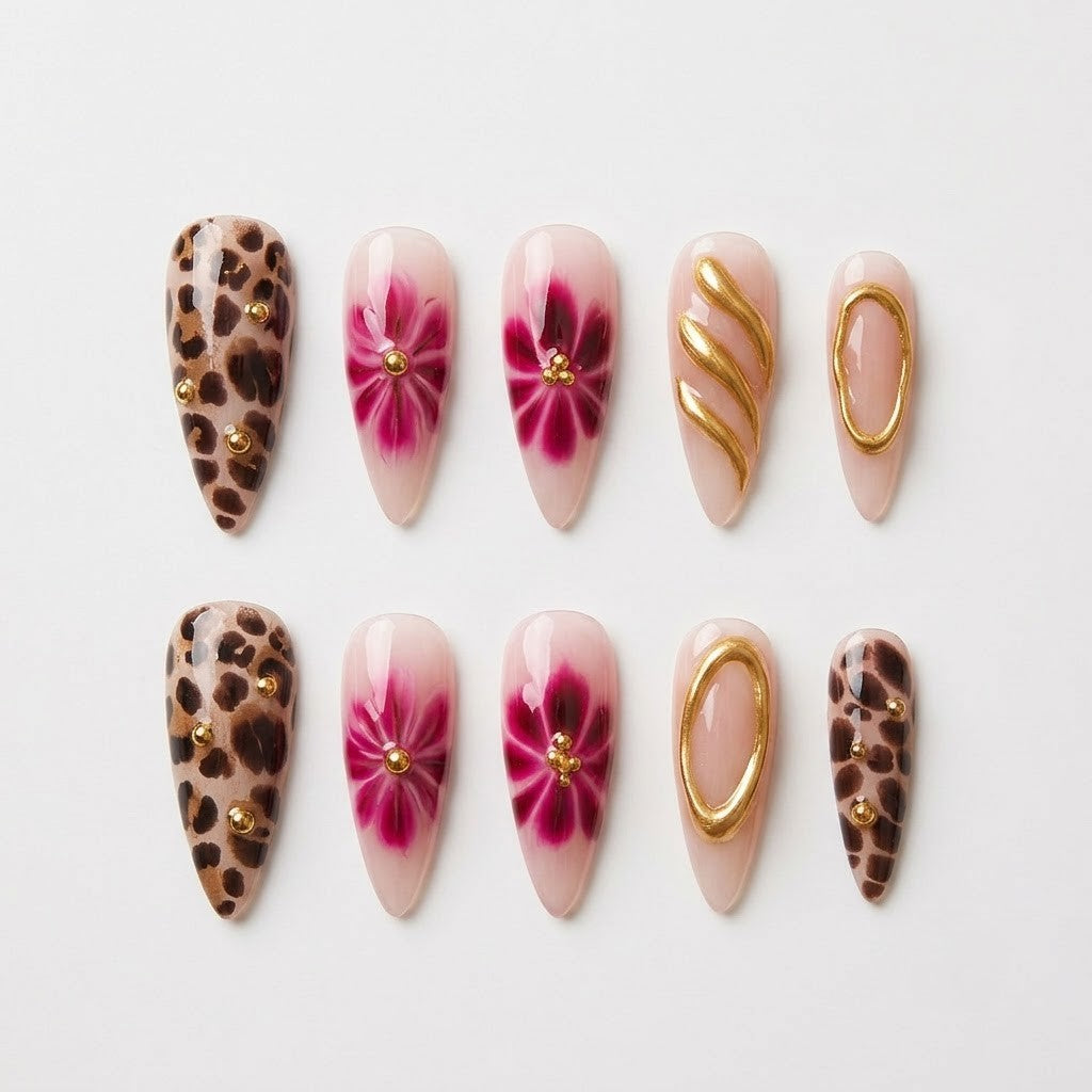 Close-up of premium handmade false nails displaying a mix of translucent nude bases, bold animal print detailing, and heavy textured gold chrome accents with miniature gems