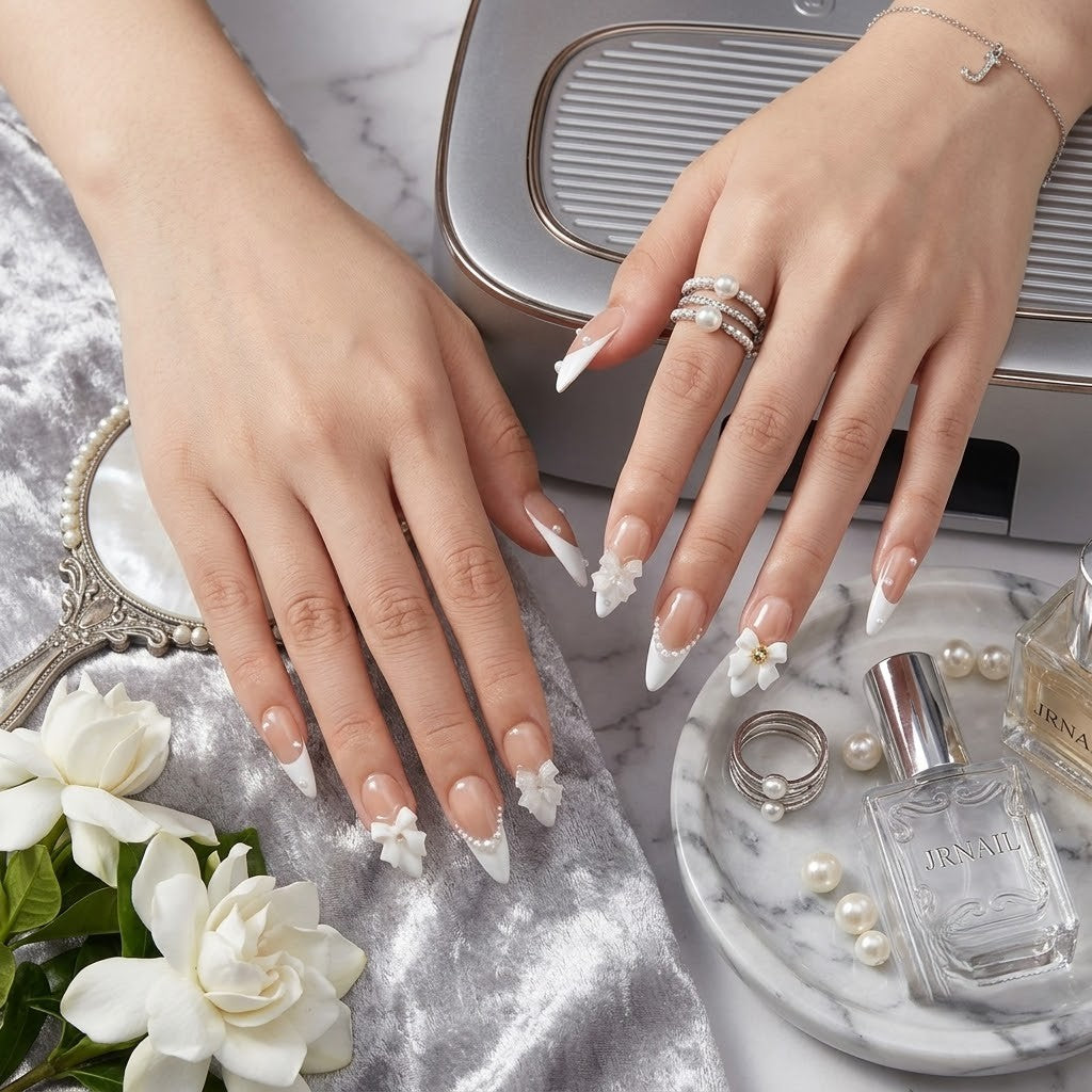 JRNAIL elegant minimalist stiletto fake nails displaying a glossy gel finish, dimensional white bows, and pearlescent details, ideal for a chic DIY home manicure or bridal look.