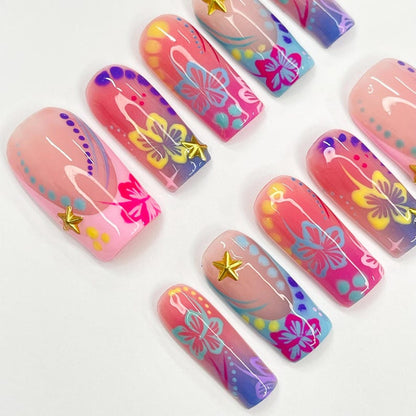 Retro Y2K press on nails with hibiscus floral art, gold star charms, and bold pink purple ombré