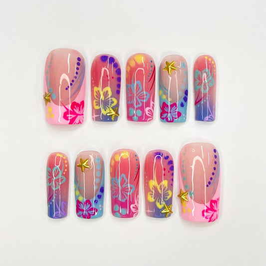 Boho summer fake nails with hand-painted flowers, gold stars, and glossy gradient finish on almond-shaped press ons