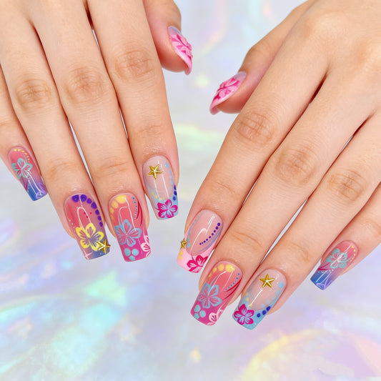 Vibrant tropical floral almond press on nails with gold star accents, pink purple coral gradient, and hibiscus designs