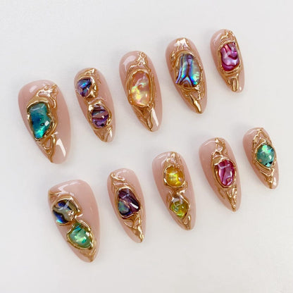 Close-up of premium, high-shine gel press-on nails with unique textured gemstone embellishments.