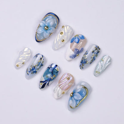 Set of 10 handmade almond press-on nails with mixed blue floral and iridescent glitter designs