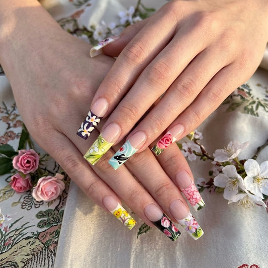 A close-up shot of a manicured hand wearing the JRNAIL Oriental Artistic-style medium square press-on nails. The glossy nails clearly display the intricate traditional art, including a geisha portrait line drawing, a red koi fish, and blooming floral designs, showing how they look when applied to natural nails